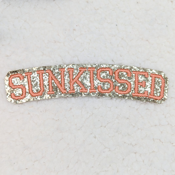 Sunkissed Embroidered Glitter Hat/Pocket Patch, pink embroidered text on a silver glitter background.