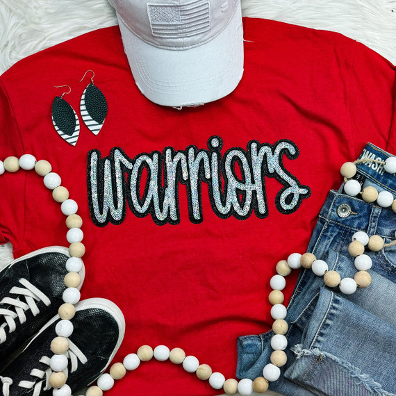 Warriors Sequin Patch, a decorative patch with sequins spelling 'Warriors' on a red t-shirt, surrounded by accessories like a white cap, black sneakers, wooden and white bead necklaces, and black leaf-shaped earrings.