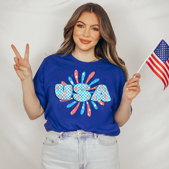 USA Lightning Bolt Retro DTF Heat Transfer, colorful lightning bolt and fireworks design on a blue t-shirt worn by a smiling woman holding an American flag.