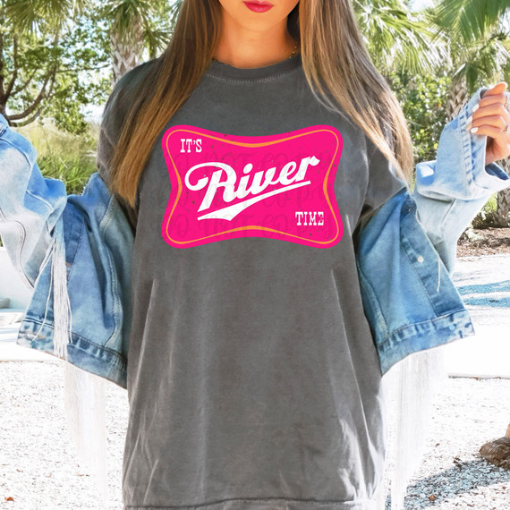 It's River Time DTF Heat Transfer, vibrant pink and white design on a grey T-shirt worn by a woman outdoors with trees in the background.