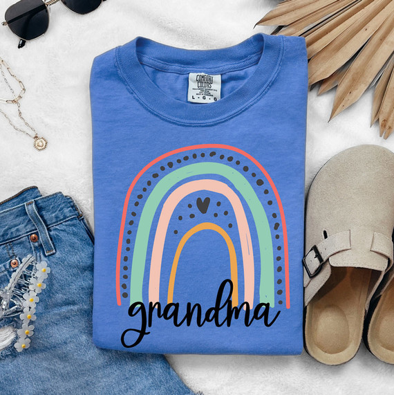 Grandma Rainbow DTF Heat Transfer, colorful rainbow design with the word grandma on a blue t-shirt.