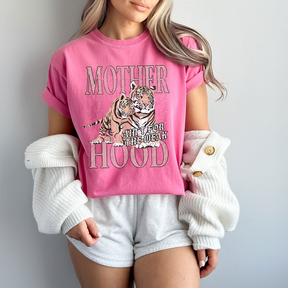 Motherhood Ain't For The Weak DTF Heat Transfer, a woman wearing a pink T-shirt with tiger graphics and empowering motherhood message.