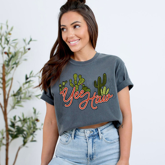 Yee Haw Cactus DTF Heat Transfer, woman wearing a gray T-shirt with cactus design and "Yee Haw" text, casual style.