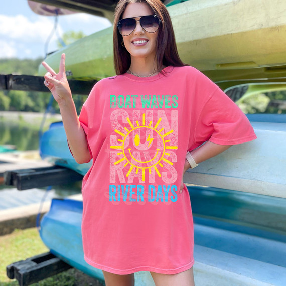 Boat Waves Sun Rays River Days DTF Heat Transfer, a vibrant pink T-shirt featuring a colorful design of a smiling sun with rays and the words 'Boat Waves,' 'River Days,' and the sun graphic.