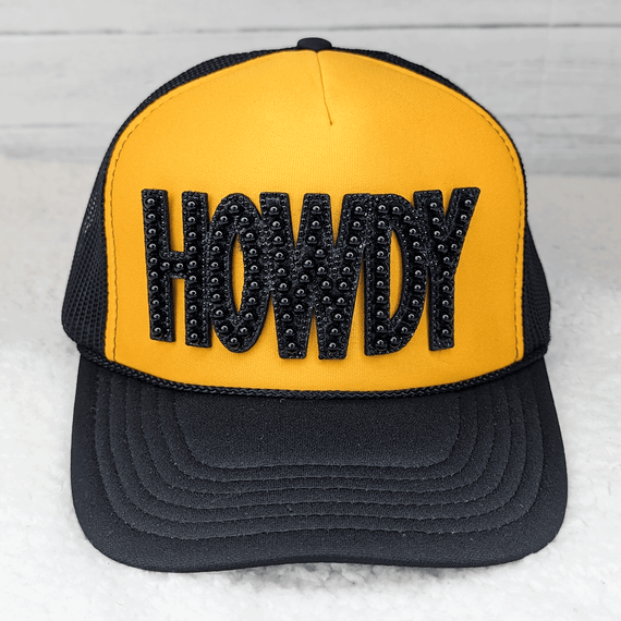 GLUE ON Howdy Black Pearl HAT/POCKET Patch, a yellow and black trucker hat with a black pearl embellished patch spelling 'Howdy' on the front.