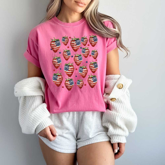 USA Strawberries DTF Heat Transfer, vibrant pink t-shirt with American flag strawberries printed design, worn by a woman.