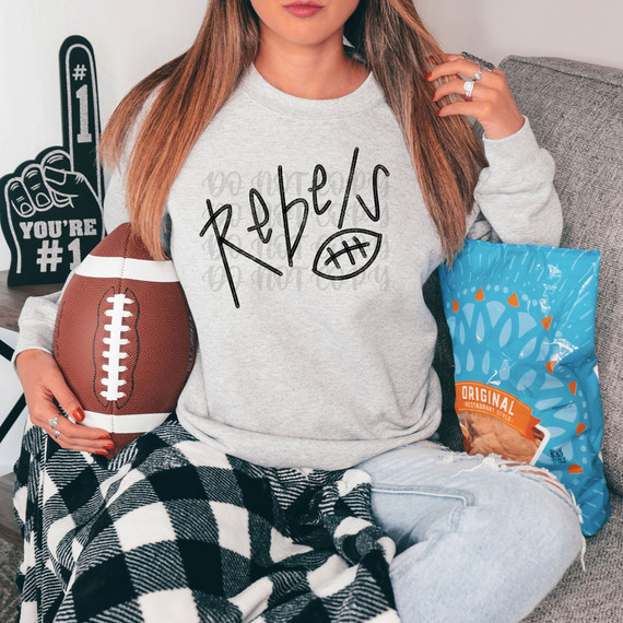 Rebels Football DTF Heat Transfer, adjustable heat transfer applied on a gray sweatshirt worn by a woman sitting on a couch with football decor.