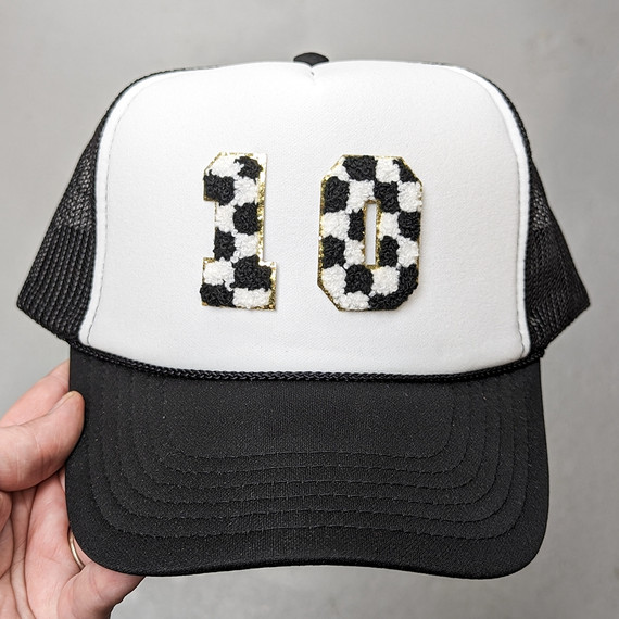 Checkered Chenille Numbers with Gold Glitter, black and white checker pattern on the number 10 patch with gold glitter outline on a white and black trucker cap.