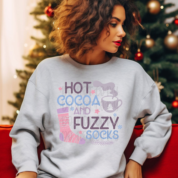 Hot Cocoa And Fuzzy Socks DTF Heat Transfer, sweatshirt with festive winter design of a cozy sock, steaming hot cocoa mug, and holiday-themed text and icons.