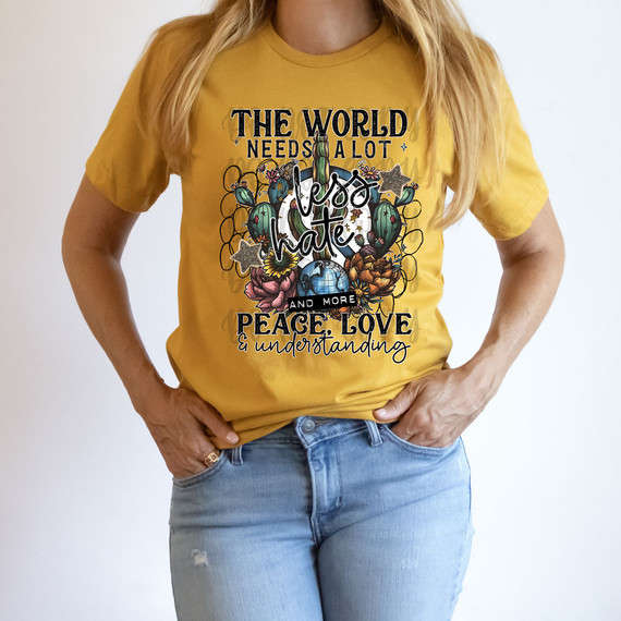 The World Needs A Lot Less Hate And More Peace, Love & Understanding DTF Heat Transfer, yellow T-shirt with a colorful graphic design promoting peace, love, and understanding.