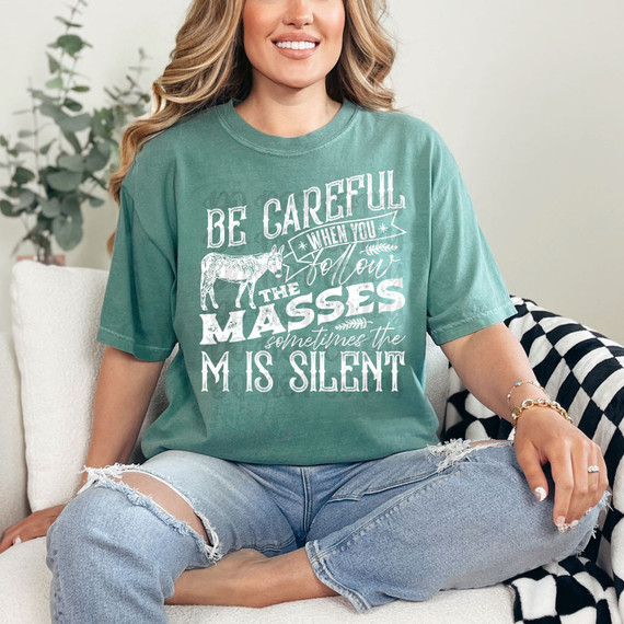 Be Careful When You Follow The Masses Sometimes The M Is Silent WHITE DTF Heat Transfer, a woman wearing a green T-shirt with the design printed on it.