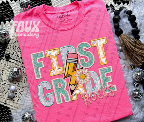 First Grade Rocks Pink DTF Heat Transfer, colorful patch design with pencils, flowers, and lettering for craft or garment decoration.