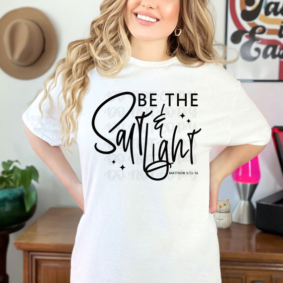 Be The Salt & Light BLACK DTF Heat Transfer, woman wearing a white t-shirt with a black inspirational biblical quote and decorative font design.