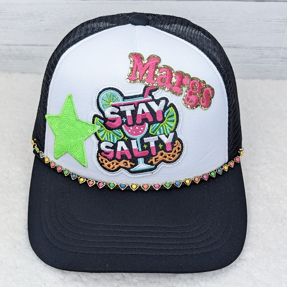 Neon Hearts Hat Chain, decorative embroidered cap with colorful patches and a heart-shaped rhinestone chain embellishment.