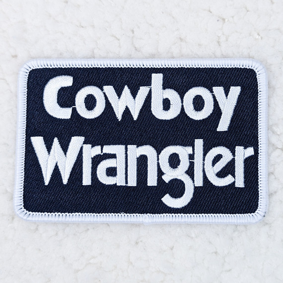 Cowboy Wrangler Embroidered HAT/POCKET Patch, embroidered patch featuring the text 'Cowboy Wrangler' with decorative stitching.