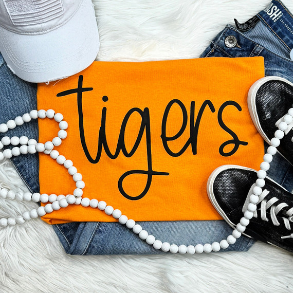 Tigers Black PUFF Screen Print Heat Transfer, orange fabric with black text, surrounded by sneakers, denim, white hat, and white beads.