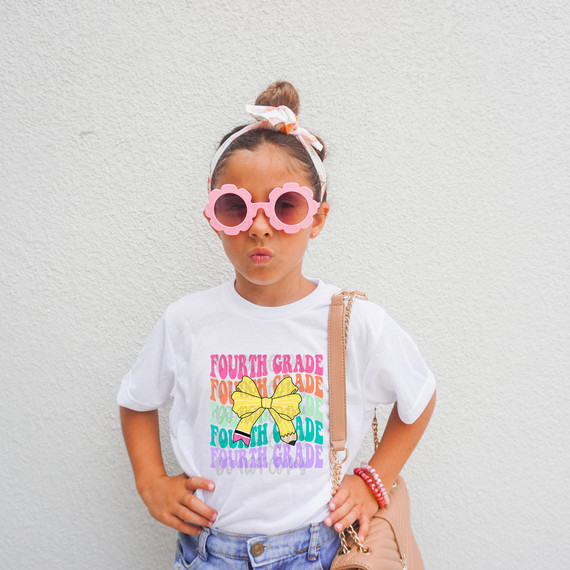 Fourth Grade Coquette Pencil Bow DTF Heat Transfer, girl wearing glasses and a T-shirt with colorful text and bow design.
