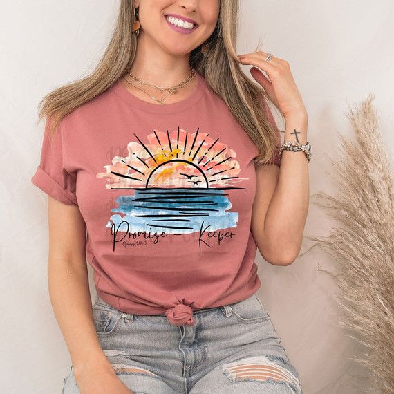 Promise Keeper DTF Heat Transfer, colorful sunset design on a pink t-shirt with water and bird illustrations.