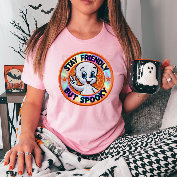 Stay Friendly But Spooky Faux Embroidery DTF Heat Transfer, Halloween-themed embroidery design on a pink T-shirt featuring a cartoon ghost and the slogan 'Stay Friendly But Spooky'.