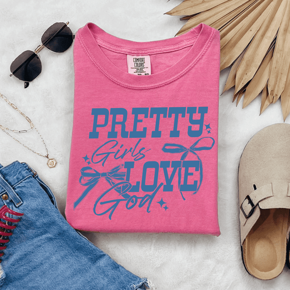 Pretty Girls Love God DTF Heat Transfer, pink T-shirt with blue and purple text and bow design.