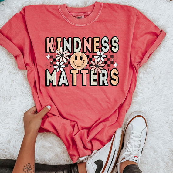 Kindness Matters DTF Heat Transfer, illustrated design with flowers and a smiling smiley face on a pink t-shirt.