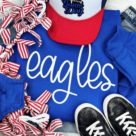 Eagles White PUFF Screen Print Heat Transfer, a white screen print design on a blue apparel item, with sports accessories and shoes surrounding it.