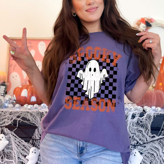 Spooky Season Checkered DTF Heat Transfer, Halloween-themed graphic T-shirt with a ghost design on a woman.