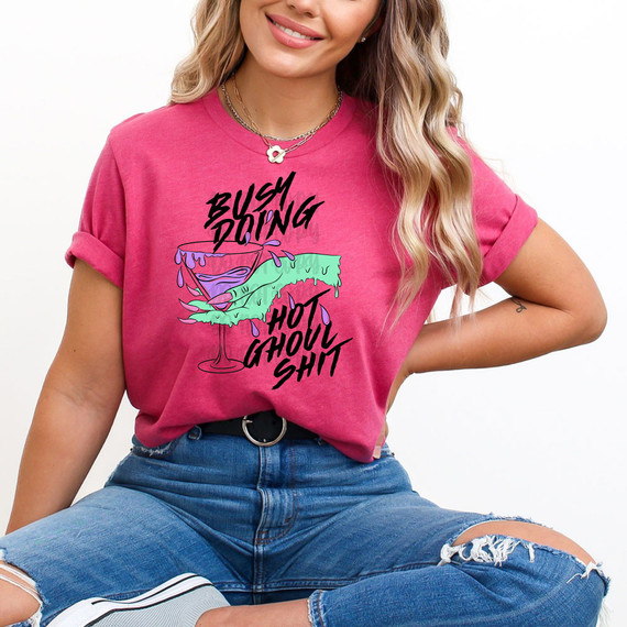 Busy Doing Hot Ghoul Shit DTF Heat Transfer, colorful graphic design on a pink t-shirt featuring a bubbling cocktail glass with dripping green and purple liquid.