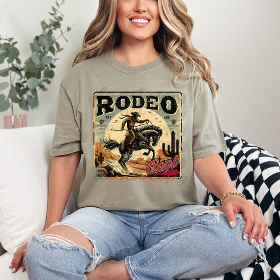 Rodeo DTF Heat Transfer, woman wearing a t-shirt with a vintage rodeo cowboy design with desert and cacti background.