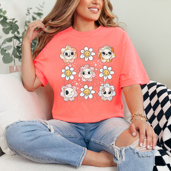 Retro Flowers DTF Heat Transfer, colorful floral and kawaii faces design on a coral pink t-shirt worn by a woman.
