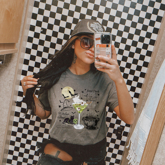 Witches Brew DTF Heat Transfer, Halloween themed graphic T-shirt featuring a cauldron, moon, black cat, and spell book design.