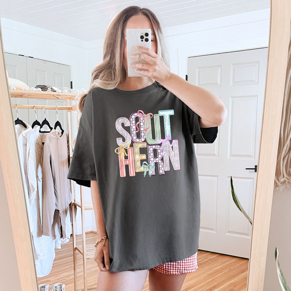 Southern Coquette Faux Embroidery DTF Heat Transfer, woman wearing a black T-shirt with colorful embroidered text design.