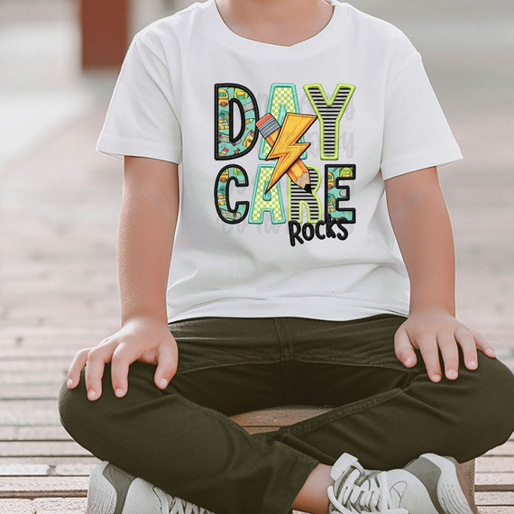 Daycare Rocks Blue/Green DTF Heat Transfer, colorful graphic T-shirt with a lightning bolt and playful text design.
