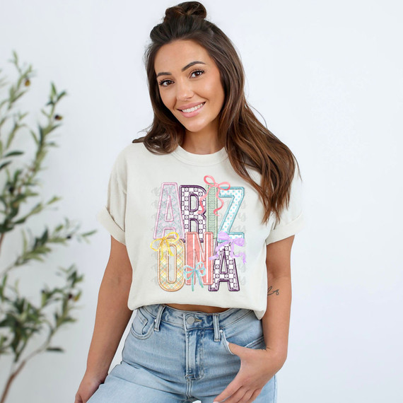 Arizona Coquette Faux Embroidery DTF Heat Transfer, colorful embroidered design on a white t-shirt worn by a smiling woman, casual fashion style.
