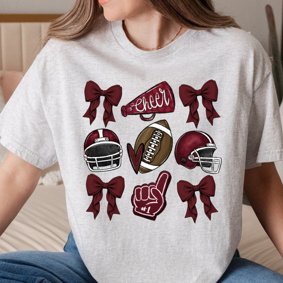 Maroon Cheer Bows DTF Heat Transfer, cheerleading-themed design on a grey t-shirt with football helmets, a cheer megaphone, a foam finger, and decorative bows.