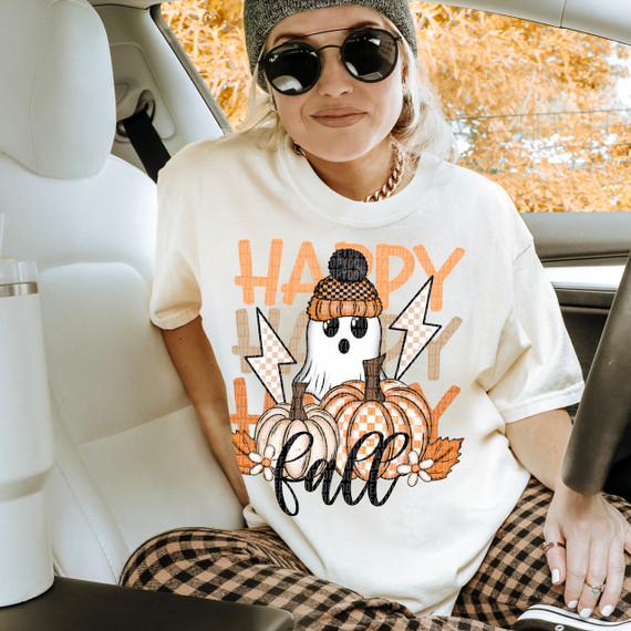 Happy Fall Checker Ghost DTF Heat Transfer, autumn-themed Halloween ghost graphic with pumpkins, lightning bolts, and fall leaves on a woman's T-shirt.