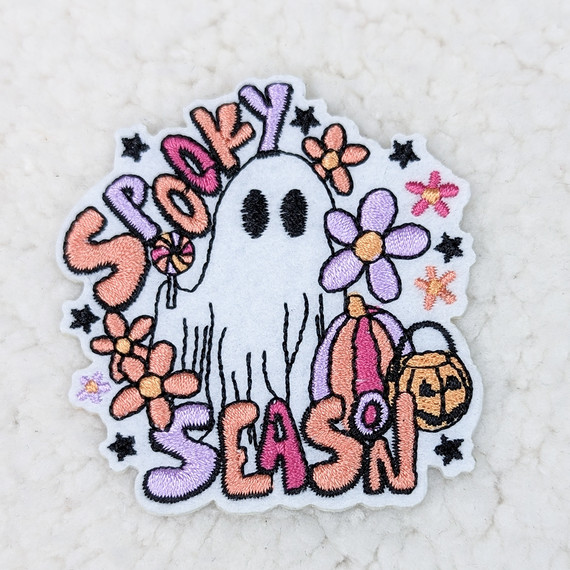 Spooky Season Embroidered HAT/POCKET Patch featuring a cute ghost holding a pumpkin bag and surrounded by colorful flowers and stars.