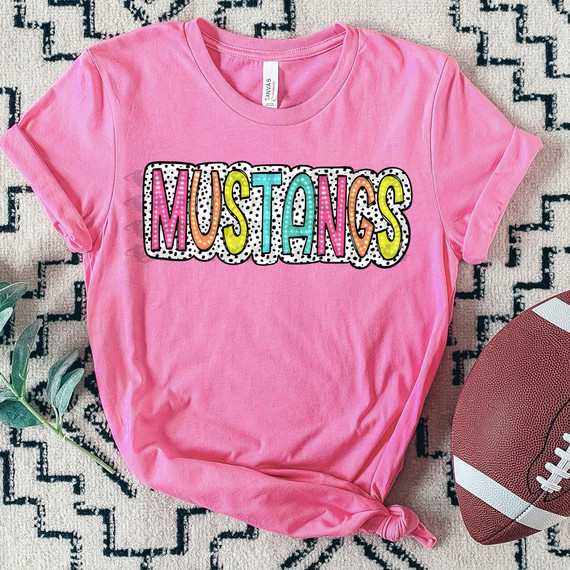 Mustangs Dalmatian Dots DTF Heat Transfer, colorful and playful design with the word 'MUSTANGS' in multicolored letters on a pink T-shirt.