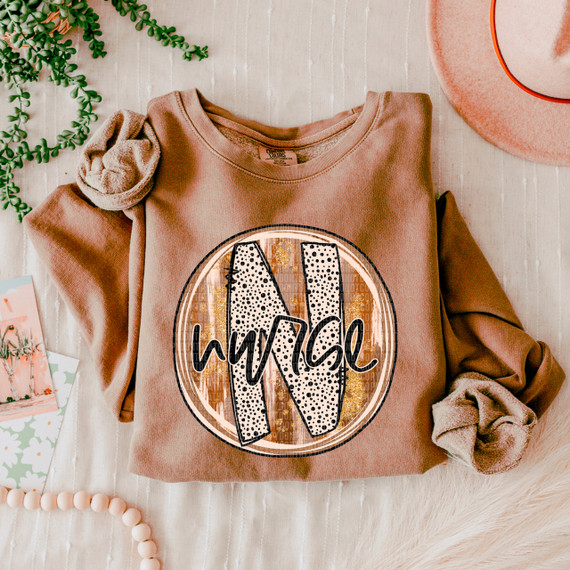 Nurse Fall Brushstrokes DTF Heat Transfer, a design on a peach-colored sweatshirt showing a large leaf with the word 'hello' in cursive.