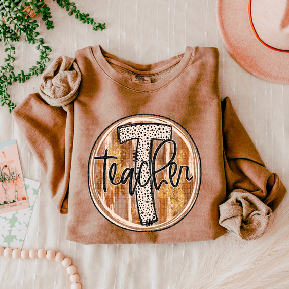 Teacher Fall Brushstrokes DTF Heat Transfer, colorful heat transfer design on a sweatshirt with the word 'Teacher' and a large letter T, surrounded by fall-themed brushstroke patterns.