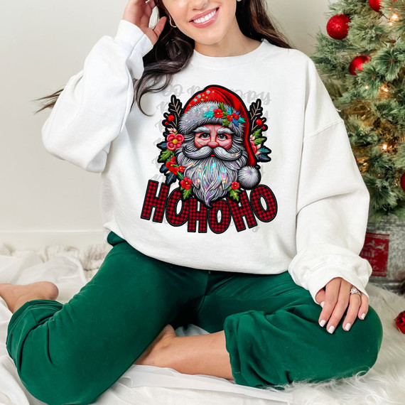 HoHoHo Buffalo Plaid Faux Patch DTF Heat Transfer, colorful Christmas Santa design on a white sweatshirt worn by a smiling woman with a Christmas tree in the background.