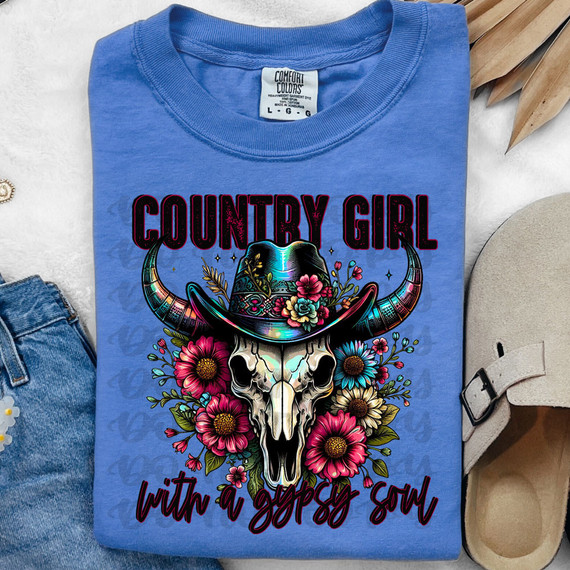Country Girl With A Gypsy Soul DTF Heat Transfer T-shirt featuring a skull with a cowboy hat, surrounded by colorful flowers, on a blue shirt.