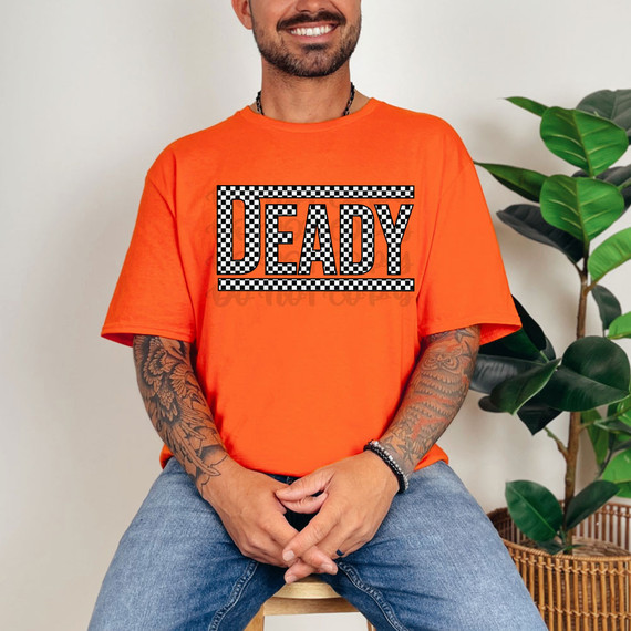 Deady Checkered DTF Heat Transfer, showing a man wearing an orange T-shirt with the black and white checkered 'DEADY' logo printed on it.