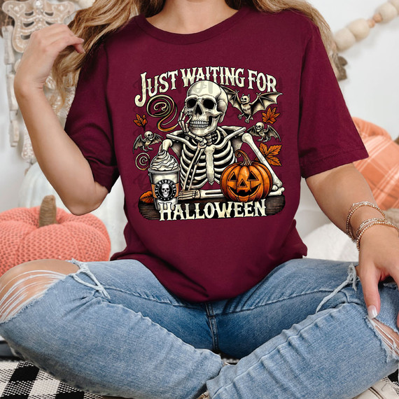 Just Waiting For Halloween DTF Heat Transfer, Halloween-themed graphic featuring a skeleton, pumpkin, bats, and autumn leaves on a maroon T-shirt.