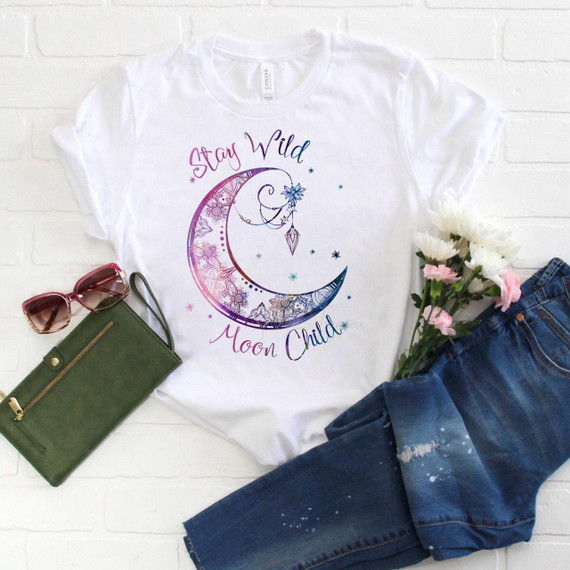 Stay Wild Moon Child Sublimation Transfer T-shirt with a moon and star design, floral accents, and vibrant colors.
