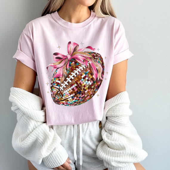 Coquette Colorful Football DTF Heat Transfer, pink t-shirt featuring a football design with colorful mosaic pattern and pink ribbon detail.