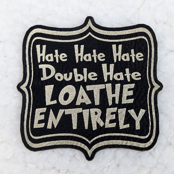 Hate Hate Hate, Double Hate, Loathe Entirely FAUX Leather Patch, black and silver embroidered patch with bold text and decorative border.