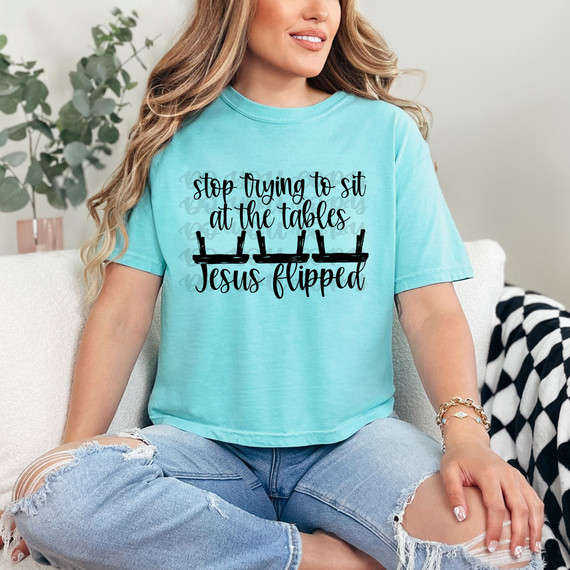 Stop Trying To Sit At The Tables Jesus Flipped DTF Heat Transfer, woman wearing a light blue t-shirt with a humorous religious graphic design.
