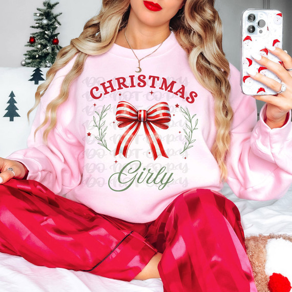Christmas Girly DTF Heat Transfer, festive pink sweatshirt with a red and white bow design and holiday-themed text for Christmas celebration.