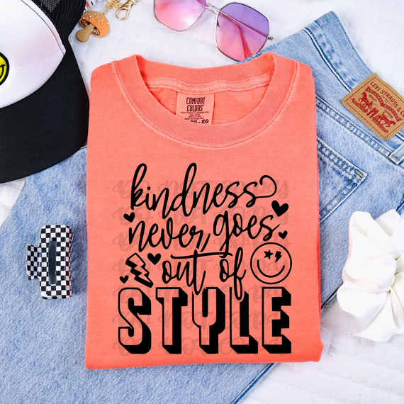 Kindness Never Goes Out Of Style BLACK DTF Heat Transfer, folded coral t-shirt with motivational quote and decorative icons on top of denim jeans.